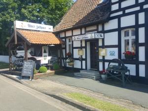a black and white building with a sign in front of it at Altes Zollhaus Hülperode in Hülperode
