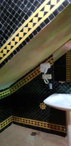 een badkamer met een wastafel en een gele en zwarte tegelmuur bij Riad Al Fassia Palace in Fès