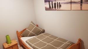 a small bedroom with a bed with a picture on the wall at Café Hausnordlicht - Ferienwohnung 2 in Dornum