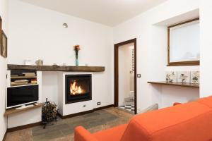 ドマーゾにあるCasa Domasoのリビングルーム(オレンジ色のソファ、暖炉付)
