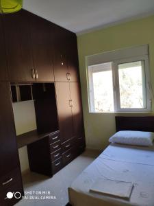 - une chambre avec un lit, une armoire et une fenêtre dans l'établissement Sunny&Seaview Apartment, à Saranda