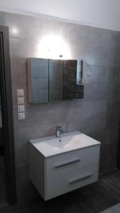 a bathroom with a white sink and a mirror at Villa Anatoli in Epáno Kefalás