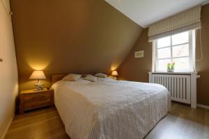 a bedroom with a large bed and a window at Marschtraum in Wyk auf Föhr