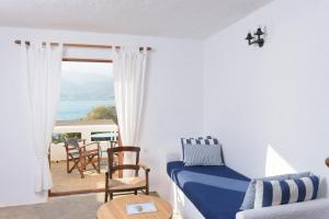 Elounda Island Villas في إيلوندا: غرفة معيشة مع أريكة وإطلالة على المحيط