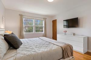 a bedroom with a bed with a dresser and a television at Close to NYC | King Bed | Free Parking in Bloomfield