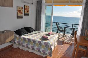 sypialnia z łóżkiem i balkonem z widokiem na ocean w obiekcie Studio Vue Mer w mieście Torremolinos