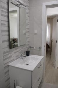 een badkamer met een witte wastafel en een spiegel bij Sun & Wave Apartment II in Nazaré