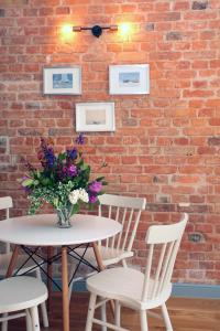 a brick wall with a table and chairs and a vase of flowers at Sopot Ostsee Apartments in Sopot