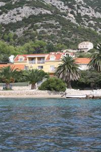 a house on the shore of a body of water at Apartman Luka in Viganj