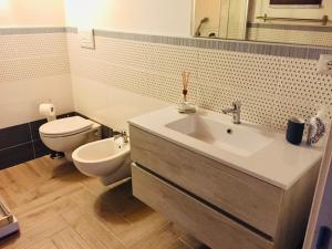 een badkamer met een witte wastafel en een toilet bij Casavacanze giadamaria in Scauri