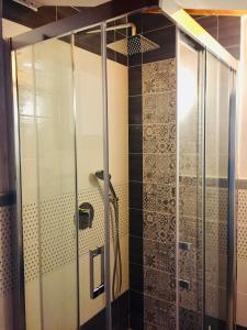 a shower with a glass door in a bathroom at Casavacanze giadamaria in Scauri