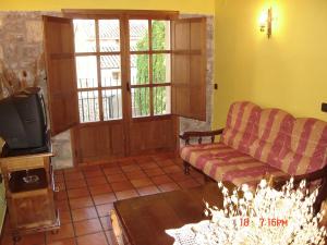 salon z kanapą i telewizorem w obiekcie Apartamentos el Portal w mieście Gea de Albarracín