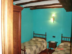 Apartamentos el Portal في جيا دي ألباراسين: غرفة نوم بسريرين وجدار ازرق