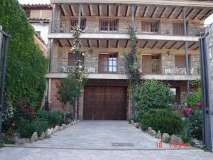 una grande casa con una porta in legno e fiori di Apartamentos el Portal a Gea de Albarracín