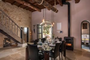 a dining room with a table and chairs and a fireplace at Boutique Villa Kalliope in Gavalochori