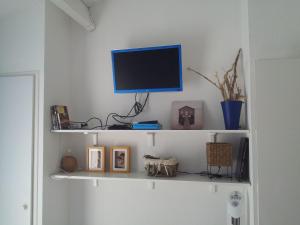 ル・ラヴァンドゥーにあるDuplex Vue sur Mer et Pieds dans l'eau Plage de Pramousquierの白い棚(壁にテレビ付)