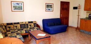 a living room with a couch and a blue chair at El Cieno 2, App. 15B in Valle Gran Rey