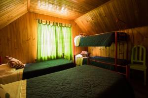 1 dormitorio con 2 literas y ventana en Hostel El Alcazar, en Villarrica
