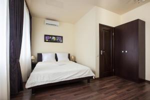 Hotel Cristal في أوديسا: غرفة نوم بسرير ذو شراشف بيضاء وارضيات خشبية