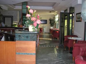 a lobby with a counter with a vase of flowers at Hotel Smeraldo in Lido di Camaiore