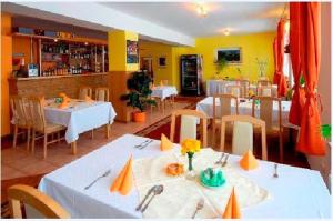 a restaurant with white tables and chairs and yellow walls at Penzión Valentína in Poprad