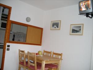 une salle à manger avec une table et une télévision dans l'établissement LOCATION STUDIO 4 PERSONNES VALFREJUS - Les Melezets 1, à Valfréjus