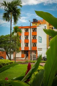 a building with a palm tree in front of it at Hotel Iguazu in Villavicencio