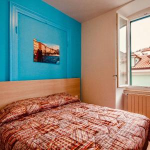 Schlafzimmer mit einem Bett mit blauer Wand in der Unterkunft B&B DREAM in Triest