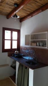 un comptoir de cuisine avec un évier et une fenêtre dans l'établissement La Cabañita de Tilcara, à Tilcara