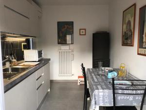 una cucina con tavolo, forno a microonde e lavandino di Appartamento Firenze Centro Amorino con terrazzo a Firenze