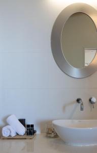y baño con lavabo blanco y espejo. en Church Bay Escape, en Oneroa