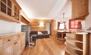 een keuken en woonkamer met een bank en een tafel bij Villa Schmalzl in Ortisei