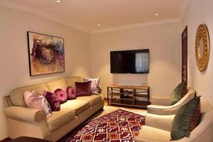 a living room with a couch and a flat screen tv at Palm Valley in Nairobi