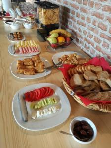 Leonidaion Guesthouse في أوليمبيا: طاولة مليئة بأنواع مختلفة من الطعام على الأطباق