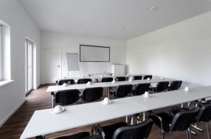an empty room with tables and chairs and a screen at Monteurzimmer Berlin Pankow mit Dachterrasse - Nur 10 min. von der A10 - 3 Zimmer/ 7 Betten in Berlin