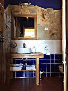La salle de bains est pourvue d'un lavabo et d'un mur carrelé bleu. dans l'établissement El Corral De Concejo, à Horcajuelo de la Sierra