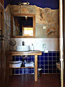 a bathroom with a sink and a blue tiled wall at El Corral De Concejo in Horcajuelo de la Sierra +32 photos