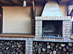a wood fired oven with a pile of logs at El Corral De Concejo in Horcajuelo de la Sierra