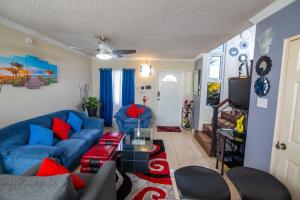 sala de estar con sofá azul y almohadas rojas en The Oasis I, Portmore Country Club, en Portmore