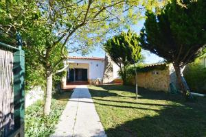 a garden with trees and a sidewalk in front of a house at Valley house - Aldeia do Meco, Sesimbra in Aldeia do Meco