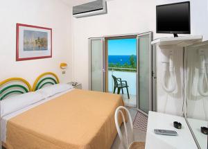 1 dormitorio con cama y vistas al océano en Hotel Vienna, en Senigallia