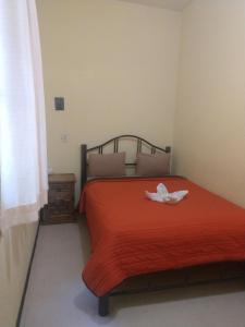 1 dormitorio con 1 cama con colcha roja en Pension Zocalo en Ciudad de México