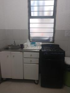 a small kitchen with a stove and a sink at Pension Zocalo in Mexico City