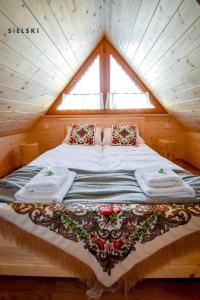 Cama en habitación de madera con ventana en Sielski Zakątek, en Zakopane