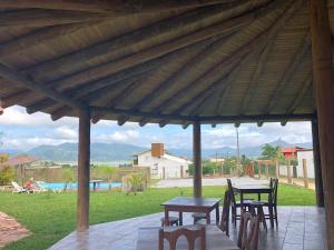 a wooden table and chairs under a wooden pavilion at Villa Suzana in Praia do Rosa