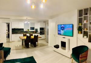 a living room with a table and a tv on a wall at VillaGrey Residence Tunari in Tunari