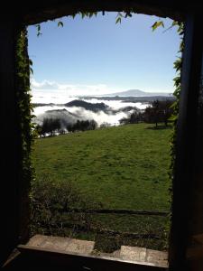 una vista da una finestra di un campo con una valle nebbiosa di Bed And Breakfast Dopo Il Settimo Cielo a Lubriano