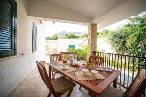 a wooden table and chairs on a balcony at Villa La Randa in Castellammare del Golfo