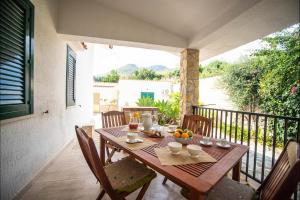 een houten tafel en stoelen op een balkon bij Villa La Randa in Castellammare del Golfo