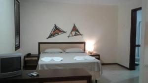 een slaapkamer met een bed met twee vliegers aan de muur bij RESORT SOLAR PIPÁ CASA 24 in Pipa
